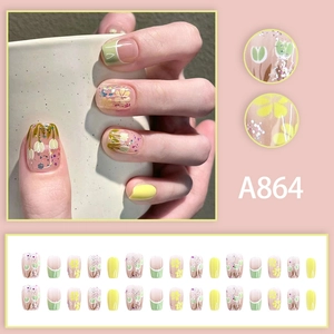 Press-on nail set with green tulip designs and yellow floral patterns on short oval tips