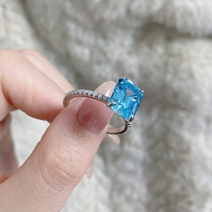 Detail of 925 silver ring featuring emerald cut blue aquamarine with micro-pavé diamonds