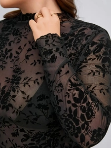Détail du haut en mesh noir avec flocage floral en velours élégant et manches longues