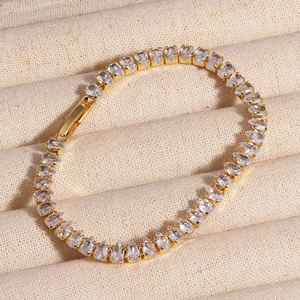 Close-up of golden tennis bracelet featuring pear-cut cubic zirconia in a prong setting