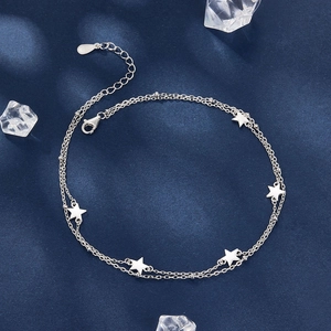 925 silver double-layer anklet featuring star charms on a textured blue fabric background