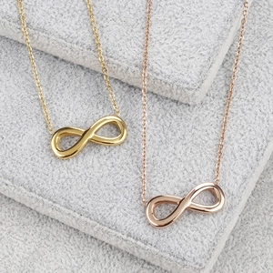 Collares con símbolo de infinito en acero de titanio dorado y oro rosa