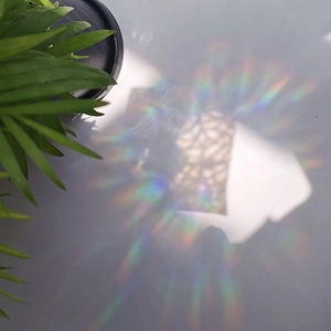 Vibrant rainbow light reflections cast by a suncatcher glass prism on a clean surface