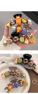 Detailed view of 3D cartoon animal and donut resin charms on a glossy brown shark hair clip