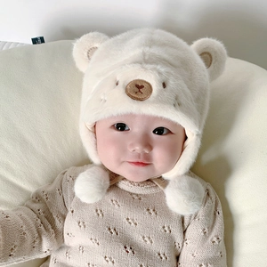 Dettaglio del cappello di peluche per neonati con orecchie 3D e laccetti con pompon