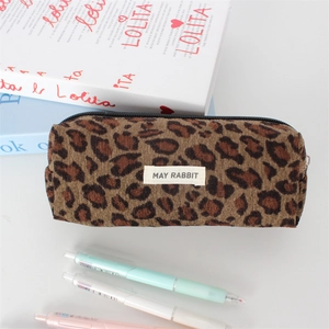 Detailed close-up of leopard print corduroy makeup bag with central logo label