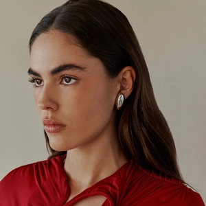 Polished silver oval dome stud earring worn by model showing minimalist style and shine
