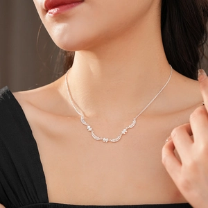 Detail of silver floral vine necklace with tiny zircons worn by a model
