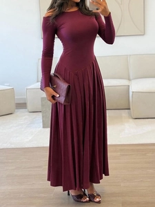 Élégante robe bordeaux à manches longues et jupe plissée dans un intérieur moderne