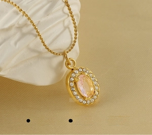 Dettaglio macro della collana in acciaio inossidabile dorato con pendente rosa ovale