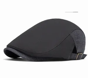 Detail of dark gray newsboy cap featuring mixed fabric textures and metal adjustment buckle