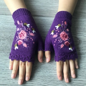Winter purple knit fingerless gloves with floral and bee embroidery on wood background