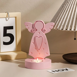 Detail of pink angel candle holder with heart cutout and white tealight on a base