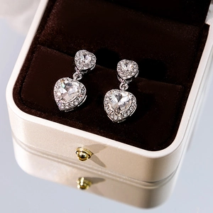 Elegant silver heart earrings with double crystal drops displayed in a luxury jewelry box