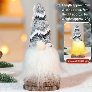Close-up of glowing Christmas gnome with a knitted hat on a rustic wooden base