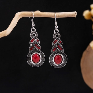 Detail of bohemian drop earrings with red stone and antique silver floral carvings