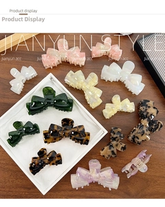 Detailed view of various acetate bow hair claws in marble and tortoiseshell patterns