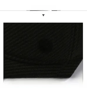 Detail of black wool peaked cap featuring fine vertical stripes and sandwich brim design