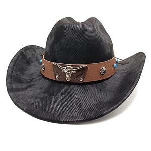Detail of black cowboy hat featuring embossed leather band with silver bull head emblem