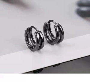 Macro view of black triple-layered hoop earrings with a sleek metallic finish