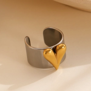 Detail of minimalist wide silver band ring with a 3D gold heart and water wave texture