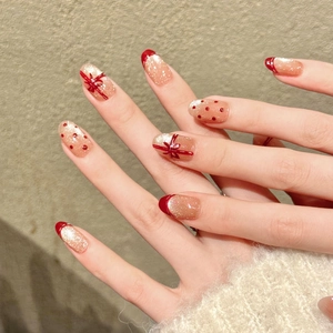 Handmade red ribbon nude press-on nails with champagne gold glitter and French tips