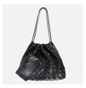 Close-up of black woven leather tote bag with silver chain strap and mini pouch