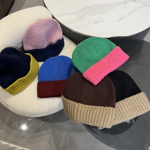 Detailed macro view showing the high-quality knit texture of color-block winter beanie hats