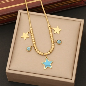 Golden star necklace set with turquoise pendants displayed on a beige jewelry gift box