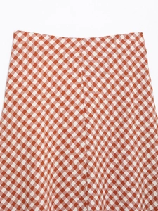 Detailed macro shot of orange and white checkered seersucker fabric texture on the skirt