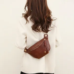 Sacoche de poitrine en cuir marron foncé portée par un mannequin pour un style tendance