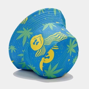 Close-up of blue canvas bucket hat featuring yellow graphics and green leaf patterns