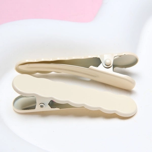 Close-up of cream wave-shaped hairpins on a white tray, durable electroplated metal finish