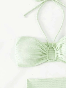 Detail of light green ribbed bikini top with halter neck and decorative central ring