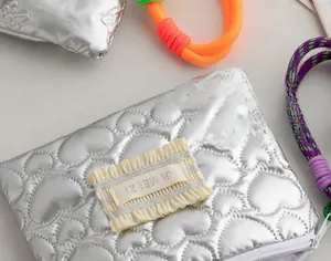 Macro shot of silver PU makeup bag with heart quilting and JI MEI ZI textile label