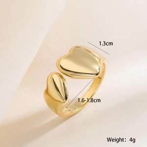 Detail shot of golden heart ring showing 1.3cm width dimension on soft beige fabric