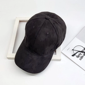 Classic black suede baseball cap styled with magazine and glasses on white backdrop