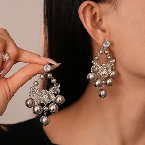 Boucles d'oreilles argentées avec boules en métal et détail fleur en zircone