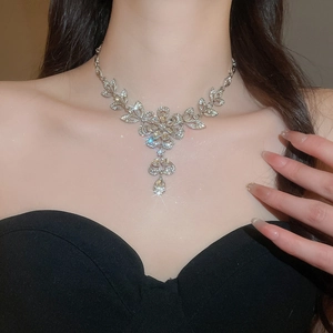 Detail of silver floral necklace with sparkling diamond petals and a teardrop pendant