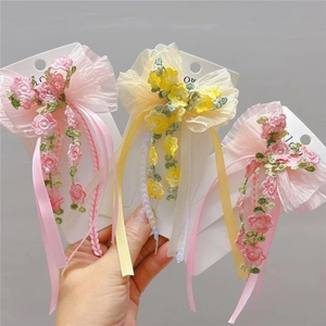 Close-up of handmade floral embroidery hair clips with delicate mesh bows and ribbons