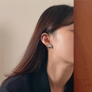 Polished silver sphere stud earrings shown on model for a minimalist aesthetic style