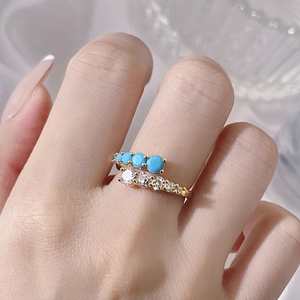 Adjustable gold plated copper ring with turquoise stones and clear cubic zirconia on hand