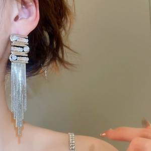 Detail of silver long tassel earrings with sparkling rhinestones worn by a model