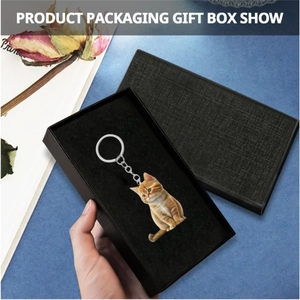 Detail of cute orange tabby cat acrylic keychain presented in a black textured gift box