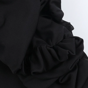Close-up of black strapless dress showing ruched fabric detail and fine knit texture
