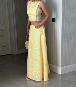 Détail du haut court sans manches en coton ajouré et jupe longue évasée à broderie anglaise
