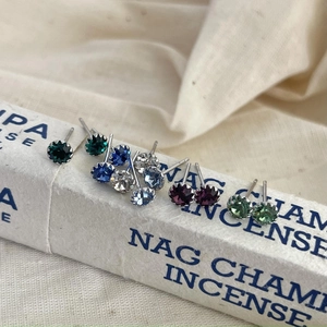 Macro shot of colorful S925 sterling silver birthstone studs on a decorative box