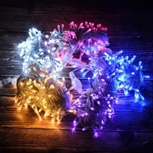 Macro shot of colorful LED star string lights with warm white and purple glow on wood