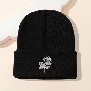 Black knitted beanie with white rose embroidery and folded brim for a stylish look