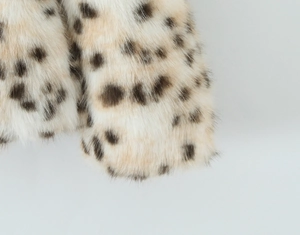 Gros plan sur la texture de fausse fourrure et l'imprimé léopard de cette veste chic